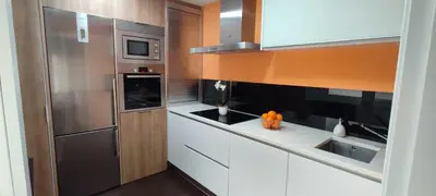 a kitchen with a stainless steel refrigerator and white cabinets at O Fogar de Cati in Ourense
