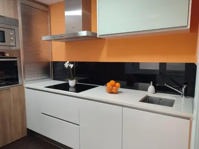 a kitchen with white cabinets and oranges on a counter at O Fogar de Cati in Ourense