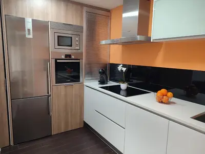a kitchen with a stainless steel refrigerator and white cabinets at O Fogar de Cati in Ourense