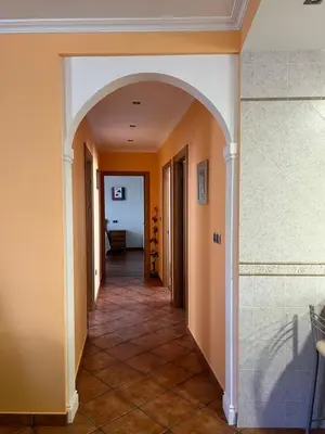 an archway in a hallway with orange walls and tile floors at Apartamento Vila O Valadouro 2 in O Valadouro