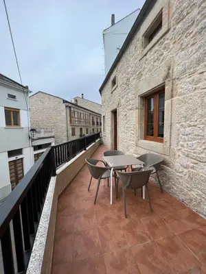 a balcony with tables and chairs on a building at Apartamento Vila O Valadouro 2 in O Valadouro