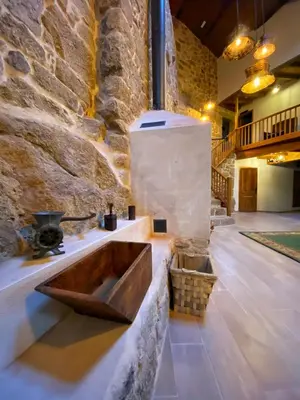 a bathroom with a wooden sink in a stone wall at Casa do Veiga in Chantada