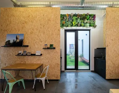 a room with a table and chairs and a wall with plants at Dpaso hostel in Chantada