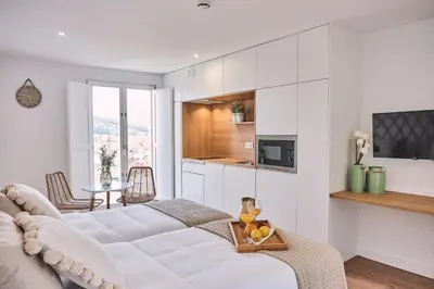 a white living room with a couch and a table at ALDARA SUITES in Santiago de Compostela
