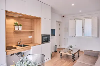 a kitchen and living room with a couch and a table at ALDARA SUITES in Santiago de Compostela