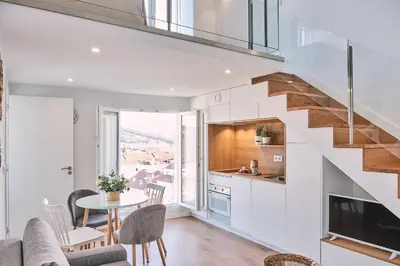 a kitchen and living room with a staircase in a house at ALDARA SUITES in Santiago de Compostela
