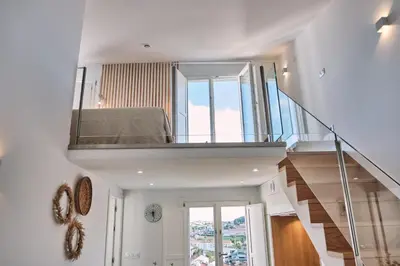 a room with a staircase with a bed and a window at ALDARA SUITES in Santiago de Compostela