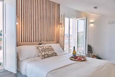 a bedroom with a bed and a large window at ALDARA SUITES in Santiago de Compostela