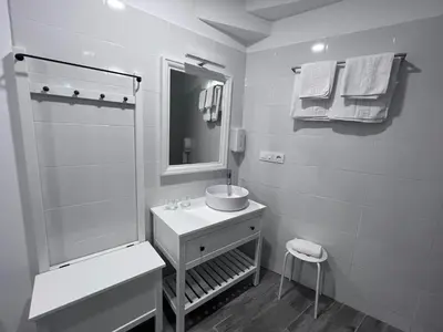 a black and white bathroom with a sink and a shower at HOSTAL CASA JULIO - Auto Check-in in Culleredo