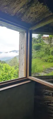 a room with a large window with a view of the ocean at Apartamentos Rurales El Bosque de las Viñas in Boal