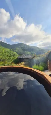 a bridge over a body of water with mountains in the background at Apartamentos Rurales El Bosque de las Viñas in Boal