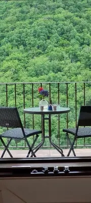 a table and two chairs on a balcony with a view at Apartamentos Rurales El Bosque de las Viñas in Boal