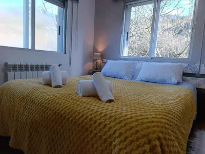 a bedroom with a large yellow bed with two pillows at Casa Loureira - Ribeira Sacra in Rosende
