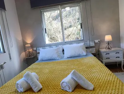 a bedroom with a yellow bed with towels on it at Casa Loureira - Ribeira Sacra in Rosende