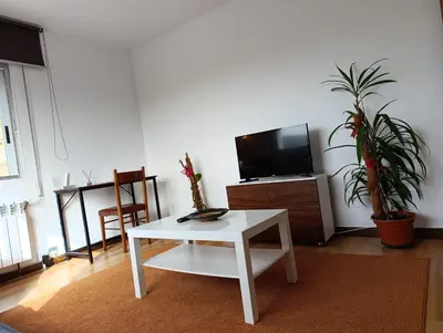 a living room with a white table and a tv at Casa Loureira - Ribeira Sacra in Rosende