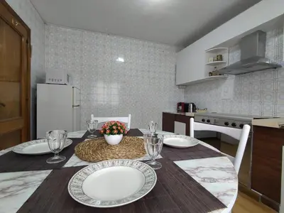 a kitchen with a table with plates and wine glasses at Casa Loureira - Ribeira Sacra in Rosende