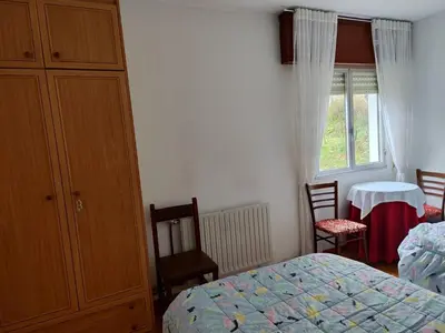 a bedroom with a bed and a dresser and a window at Casa da Fontiña in Seoane