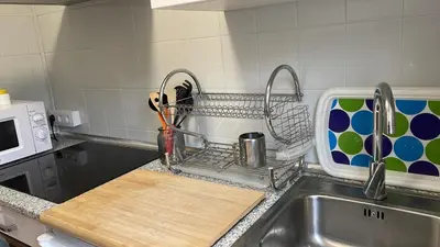a kitchen sink with a dish drying rack next to a sink at Casa da Fontiña in Seoane
