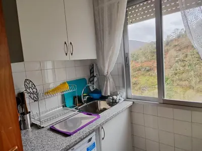a kitchen counter with a sink and a window at Casa da Fontiña in Seoane