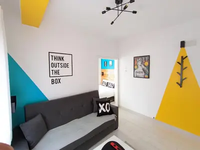 a living room with a couch and a sign on the wall at XOXO - Arco in Ponferrada