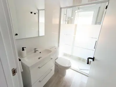 a white bathroom with a toilet and a sink at XOXO - Arco in Ponferrada