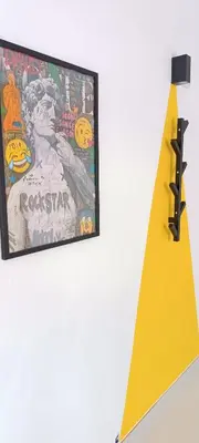 a picture hanging on a wall next to a yellow object at XOXO - Arco in Ponferrada
