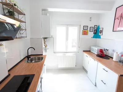 a kitchen with white cabinets and a sink at XOXO - Arco in Ponferrada