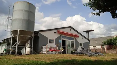 a building with a silo next to a silo at Albergue A Nave de Ferreira in Lugo