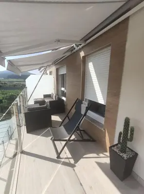 a balcony with a chair and a couch and a cactus at Foz, ven y disfruta Galicia in Foz