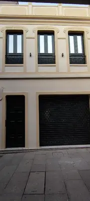 a building with two garage doors and three windows at Mi Refugio in Monforte de Lemos