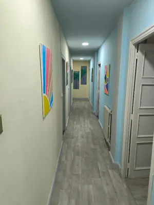 a hallway with blue walls and a long hallway with paintings at La Puebla in Ponferrada
