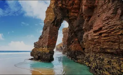 an arch in the rocks on the beach at MODERNO PISO CON LA MEJOR TERRAZA DE RIBADEO Y VISTAS MARAVILLOSAS in Ribadeo
