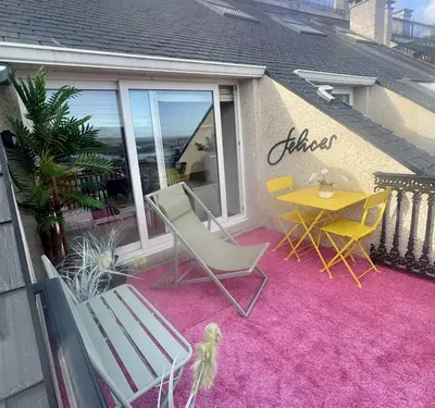 a patio with a table and chairs on a pink rug at MODERNO PISO CON LA MEJOR TERRAZA DE RIBADEO Y VISTAS MARAVILLOSAS in Ribadeo