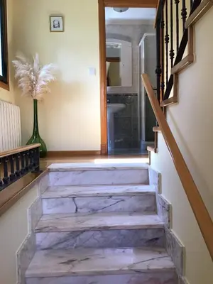 a staircase with marble floors and a glass door at Casa Tino in Montederramo