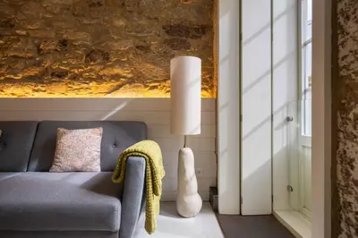 a living room with a couch and a lamp at The Tailor's Garden in Santiago de Compostela