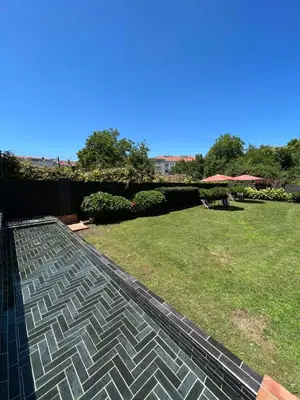 a backyard with a lawn and a brick patio at The Tailor's Garden in Santiago de Compostela