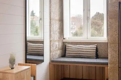 a bench in a room with two windows at The Tailor's Garden in Santiago de Compostela