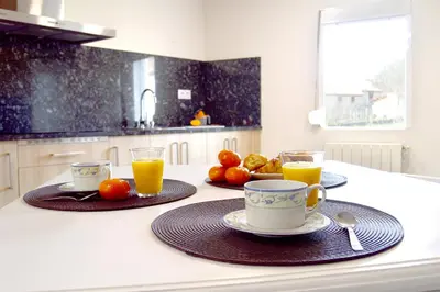 a kitchen with two cups of orange juice and fruit at Casa Galegos in Pantón