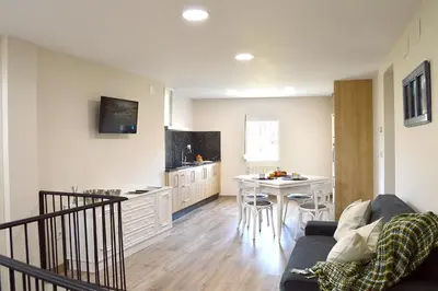 a living room with a couch and a kitchen with a table at Casa Galegos in Pantón