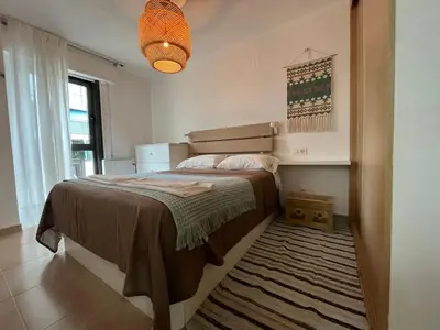 a bedroom with a large bed with a rug at Apartamento con terraza,2 min de la playa, Ares in Ares