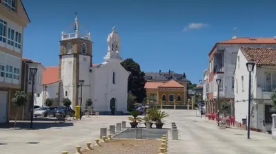 a city street with a church and a clock tower at Apartamento con terraza,2 min de la playa, Ares in Ares