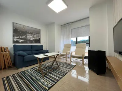 a living room with a blue couch and chairs at Apartamento con terraza,2 min de la playa, Ares in Ares