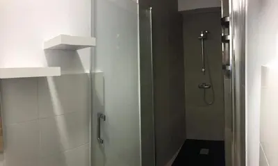 a shower with a glass door in a bathroom at Nest Flats Santiago VUT in Santiago de Compostela
