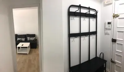 a room with white walls and a door and a room with a chair at Nest Flats Santiago VUT in Santiago de Compostela