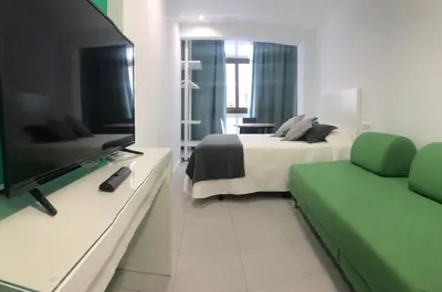 a bedroom with a bed and a tv and a couch at Nest Flats Santiago VUT in Santiago de Compostela