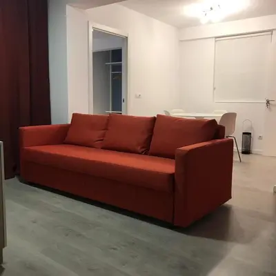 a red couch in a living room with a table at Nest Flats Santiago VUT in Santiago de Compostela