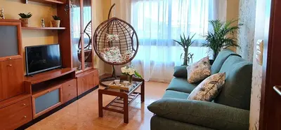 a living room with a blue couch and a fan at Apartamento Inma in Silleda