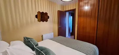 a bedroom with a bed and a wooden door at Apartamento Inma in Silleda
