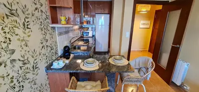 a kitchen with a counter with chairs and a counter top at Apartamento Inma in Silleda