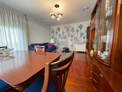 a dining room with a wooden table and a couch at Oktheway Rua Nova 3D in Sarria